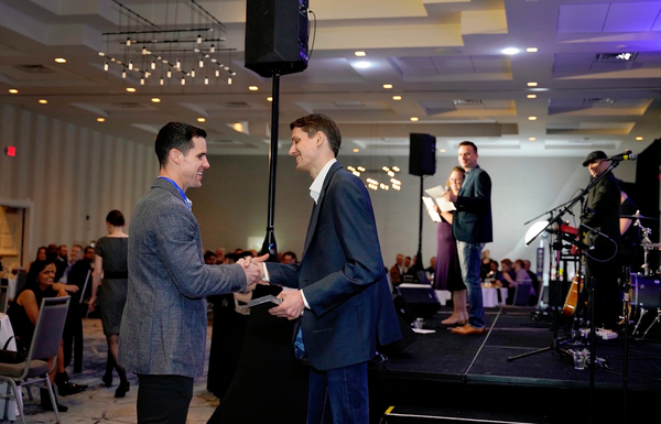 Two colleagues shaking hands at a professional event