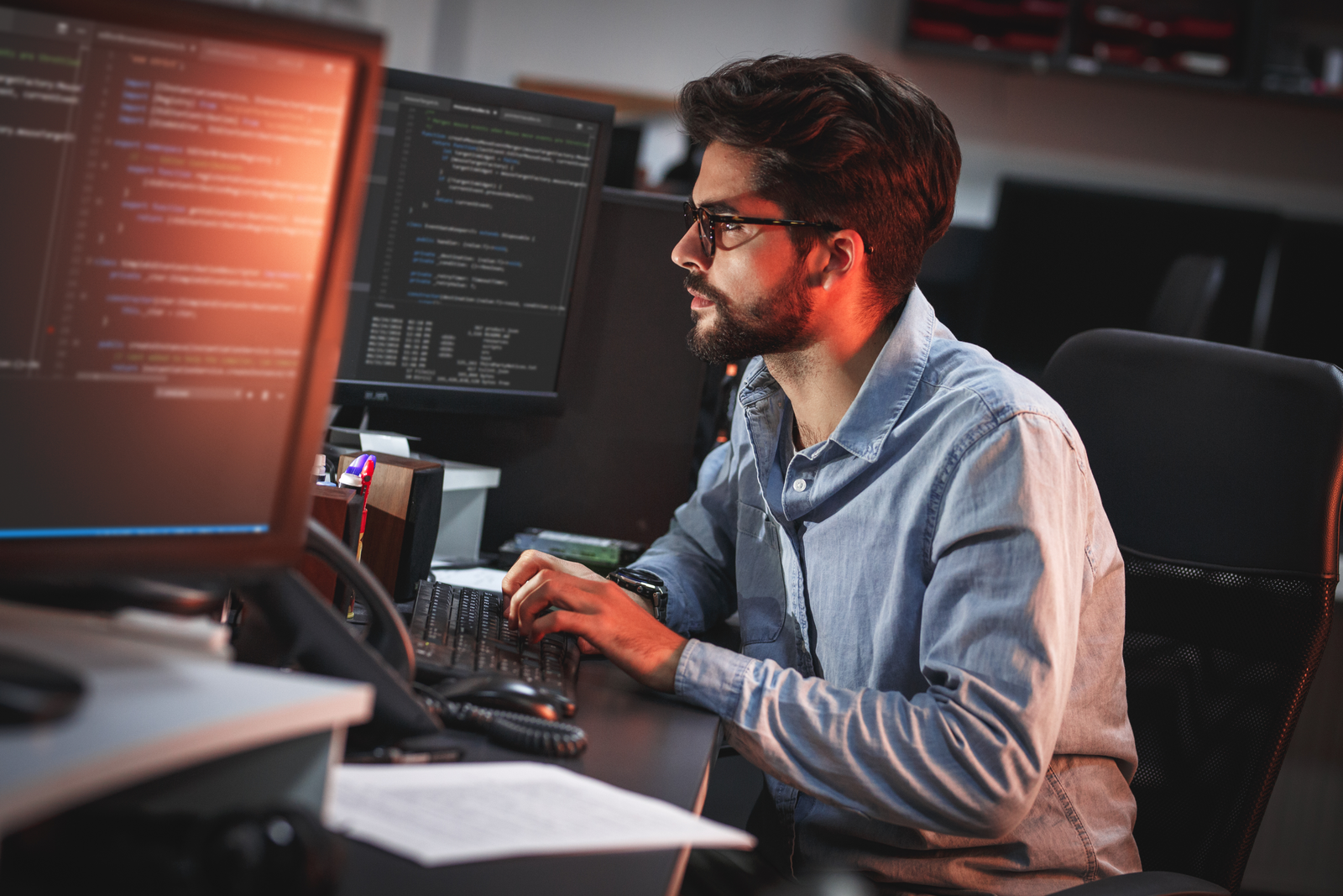 Engineer collaborating across multiple monitors in a secure workspace